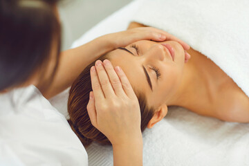 Womans face recieving procedure of professional manual relaxing massage
