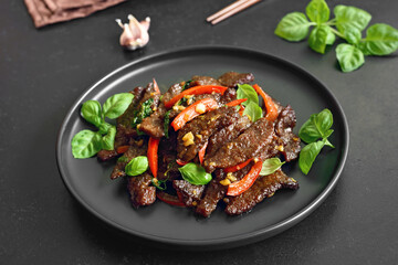 Thai beef stir-fry with pepper and basil on plate