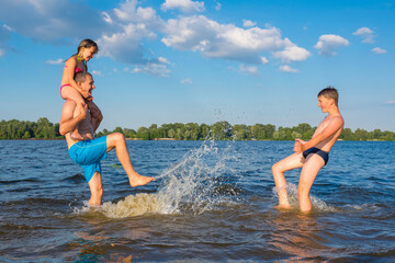 The family is playing in the river on a sunny day. Family Beach Vacation Games, Vacation, Games.