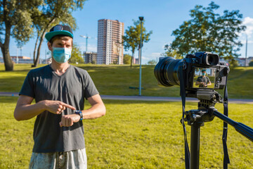 The Concept of Health and Lifestyles at a Distance. A blogger wearing a protective mask talks about...