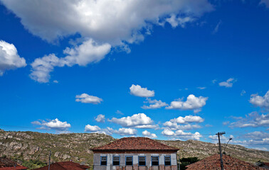 Fototapeta na wymiar Ancient colonial house and blue sky with clouds, Diamantina, Brazil 