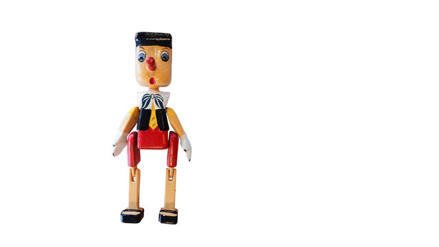 A Colorful Wooden Puppet "Pinocchio", The Symbol of Lying.  Isolated / Die Cut on White Background with Copy Space for Text. Selection Path or Clipping Path Included.