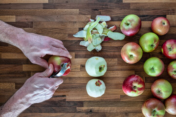 Peeling fresh red apples for apple sause - 384791900