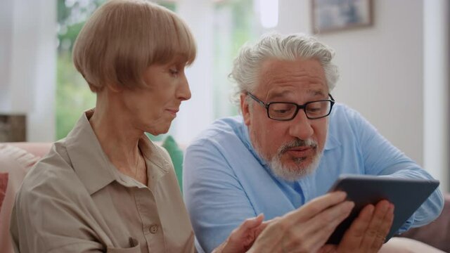 Man looking at tablet screen with woman.Grandparents using tablet for video call