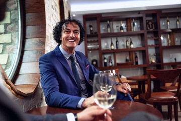 Sharp dressed businessman holding a glass of wine