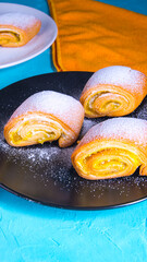 Baking strudel,cake on a black and white plate on a bluish background with a yellow napkin,space for text