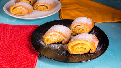 Baking strudel,cake on a black and white plate on a bluish background with a yellow napkin,space for text