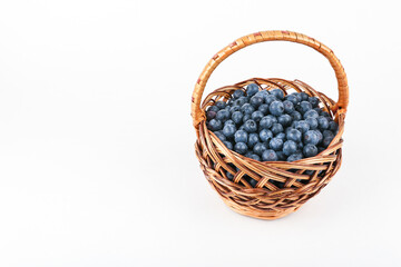 Fototapeta na wymiar blueberries in a wicker basket on a white background