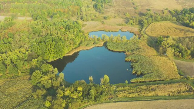 Aerial flying above stunning beautiful rural Europe landscape autumn  with fields, forests, lakes. Wonderful drone video for ecological concept.