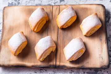 Baking strudel,rolls dusted with powder on a black and white background,on a wooden Board with a space for text,top view