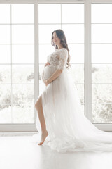 beautiful young pregnant woman in long white dress