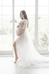 beautiful young pregnant woman in long white dress