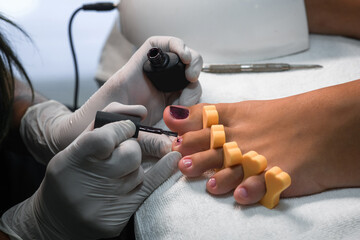Young woman getting professional pedicure in beauty salon, closeup