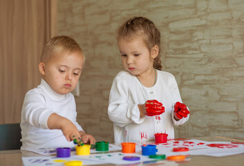 Little children paint with paints. The kids got their hands dirty in gouache. A cute girl and a boy...