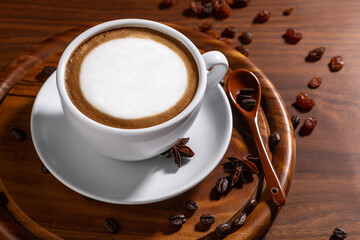 Cup of cappuccino coffee with cacao topping over dark rustic wooden background