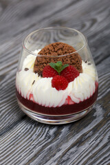 Cooking cream cheese dessert with raspberry jelly. The ingredients are laid out on the table surface. Decorated with cookies, raspberries and mint.