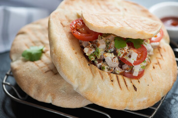 Closeup of two doners with meat and vegetable stuffing served in pita bread, studio shot