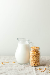 Vegetable pea milk in a milk jug and peas in a jar. Gluten-free, lactose-free product. Copy space.