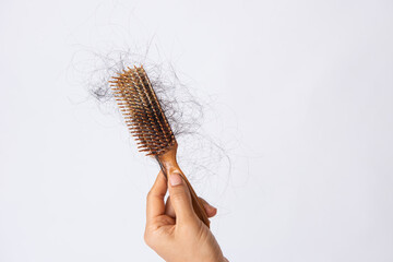 Woman hand hoding hairs fall in comb, hair fall everyday serious problem. Girl Hairs fall with a...