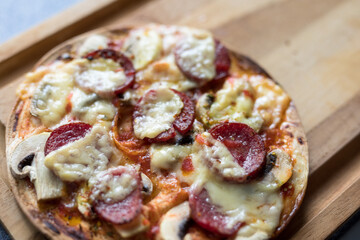 Pepperoni pizza with mozzarella cheese, white mushroom and sriracha