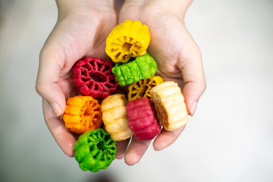 Young indian woman holding colorful fried food made of potato starch and sago called far far fryums which is a popular food in north india or a great snack