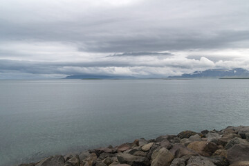 View sea on rocky seashore at Reykjavik at cloudy day.