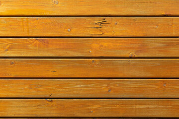 Beautiful horizontal texture of yellow and brown boards with knots and resin is in the photo