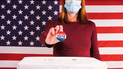 Voting woman showing Vote button with ballot box and american flag.