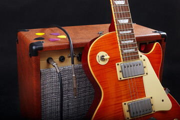 Fototapeta na wymiar Guitar combo amplifier with guitar on black background.