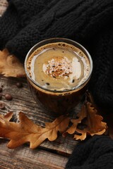 Espresso coffee with a black scarf and oak leaves on the table