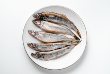 Fish lies on plate on white background