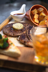 Grilled t-bone steak with grilled vegetables and whiskey glass in a restaurant table