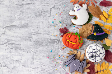 Halloween background with cookies, leaves, sunflowers and spiders, copy space. Halloween objects on textured concrete with space for text. Vintage background Halloween celebration. Flat lay