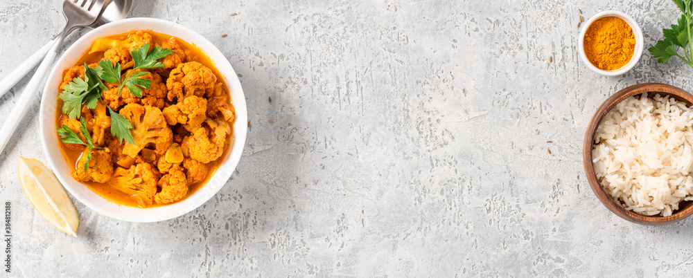 Sticker Cauliflower stew with curry, cumin, turmeric and other spices in a white bowl on a gray concrete background top view. Free space for text. Curry roasted cauliflower. Copy space.