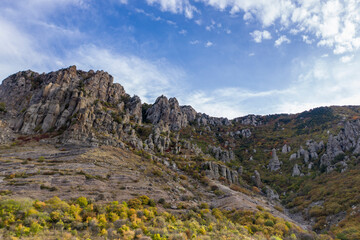 a panoramic view of the beautiful mountains with unusual ledges and rocks against the background of the sky and the valley filmed from a drone