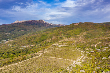 Fototapeta premium a panoramic view of the beautiful mountains with unusual ledges and rocks against the background of the sky and the valley filmed from a drone