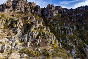 a panoramic view of the beautiful mountains with unusual ledges and rocks against the background of the sky and the valley filmed from a drone