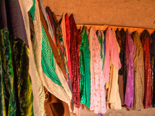 Various colorful vintage scarves hanging on the mud wall in an oriental house in mesopotamia