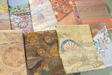 畳に並べられた格式高い織りで作られた帯
