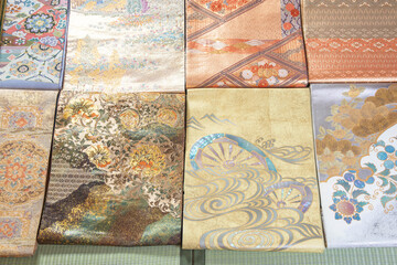 畳に並べられた格式高い織りで作られた帯
