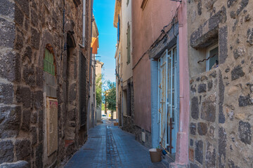 Fototapeta na wymiar Small street at Agde Centre with old Buildings , background blue sky