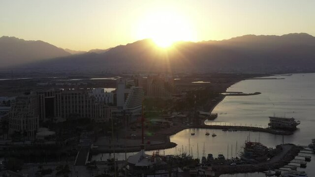 Sunrise over Eilat and The Red Sea, with waterfront hotels and Edom mountain ridge in the horizon, Aerial view.