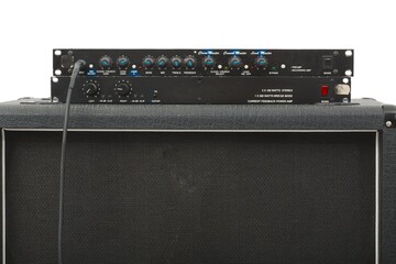 Big guitar amplifier with preamp and power amp on a speaker cabinet, instrument cable connected