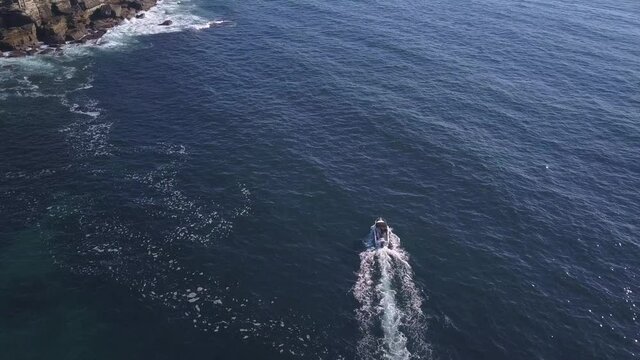 Top down overhead flyover a single speed fishing boat on the ocean at Sydney Coastal waters