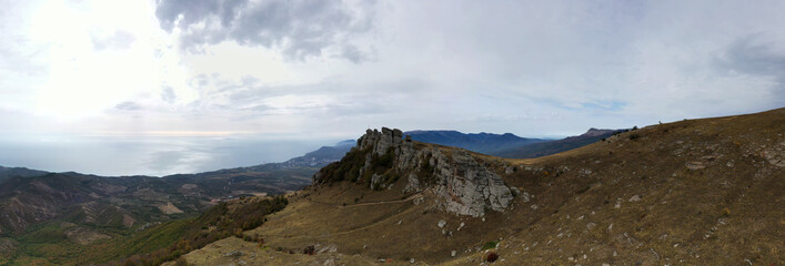 a panoramic view of the beautiful mountains with unusual ledges and rocks against the background of the sky and the valley filmed from a drone