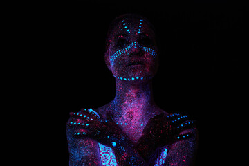 Art woman cosmos in ultraviolet light. Entire body is covered with colored droplets. Girl posing in...