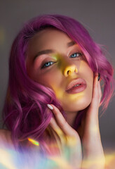 Fototapeta premium Portrait of a woman with bright colored flying hair, all shades of purple. Hair coloring, beautiful lips and makeup. Hair fluttering in the wind. Sexy woman with short hair. Professional coloring
