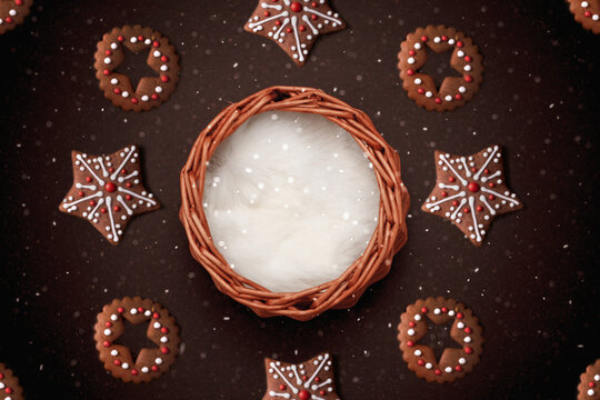 wicker basket with fur on a dark background with snow and christmas cookies
