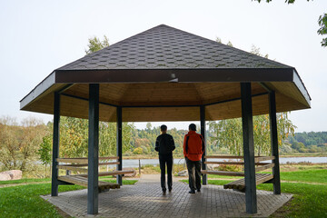 Friends walking in arbor in the city park