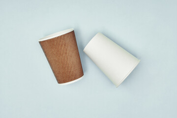 Paper cup in hand on a colored background. Eco-friendly materials in a coffee shop, biodegradable disposable tableware. Close up.